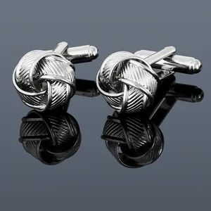Macro detail of silver twisted knot cufflinks with polished finish and swivel back