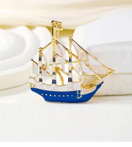 Macro view of detailed pirate sailing ship brooch with gold alloy and blue enamel