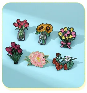 Macro detail of six enamel flower pins featuring colorful tulips, peonies, and strawberries