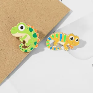 Detail of colorful enamel lizard badges with green and orange patterns on alloy metal