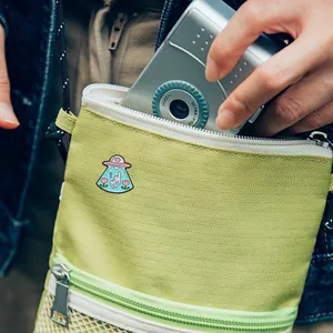 Broche en émail chat OVNI dessin animé fixée sur un sac à bandoulière vert menthe déco