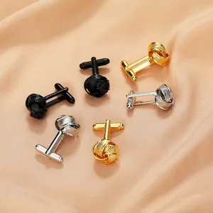Men's twist knot cufflinks in black, gold, and silver on a silk fabric background