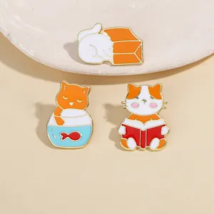 Tres lindos pines de esmalte de gatos en una caja, pecera y leyendo un libro de cuentos