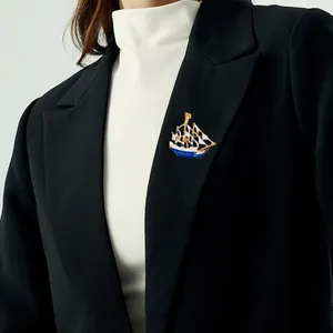 Fashionable alloy sailing ship brooch with blue enamel on a black suit lapel