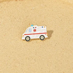 Detail shot of cartoon ambulance enamel pin with gold plating and medical cross badge