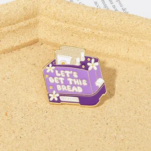 Detail of purple toaster enamel pin with Let's Get This Bread text and daisy flower