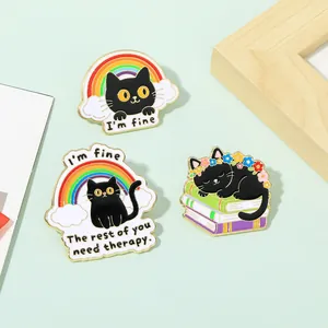 Detailed view of three black cat enamel pins featuring colorful rainbow and book designs