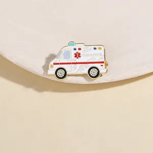 Detailed view of ambulance enamel brooch with gold edges on white display tray