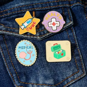 Detail of four medical enamel pins featuring cure and health symbols on denim fabric
