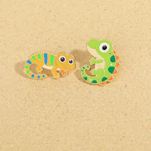 Detail of colorful enamel lizard pins with yellow and green chameleon designs in alloy metal
