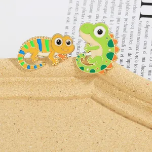 Detail of colorful enamel lizard and dinosaur animal brooches with gold-plated edges