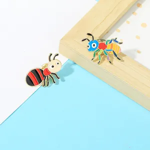 Close-up of colorful enamel cartoon insect pins on light blue background props