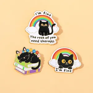 Detailed view of black cat enamel pins featuring rainbow and book designs