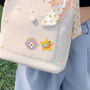 Cartoon enamel health and cure medical badges pinned on a floral white handbag