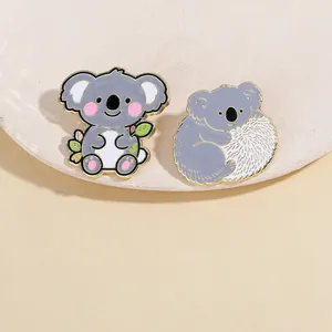 Dettagli di spillette koala in smalto carino con bordi dorati e motivi floreali
