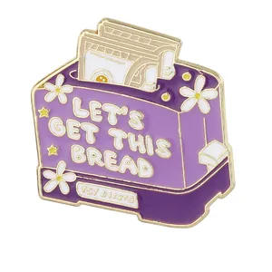 Enamel purple toaster pin with 'LET'S GET THIS BREAD' quote and daisy floral details