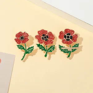 Detailed view of red crystal poppy brooches with gold Remembrance Day engravings