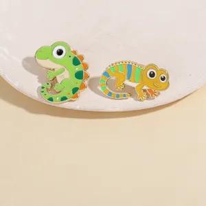 Detail shot of two cute cartoon lizard enamel pins with vibrant colors on display board