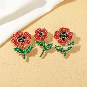 Detail of red poppy brooches with crystal rhinestones and Remembrance Day text engraving