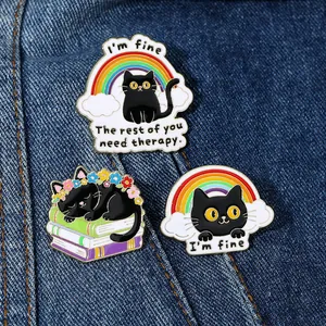 Detailed macro view of three colorful cat enamel pins on blue denim fabric texture