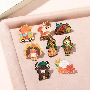 Macro shot of 7 Thanksgiving enamel pins including squirrel and turkey on beige tray