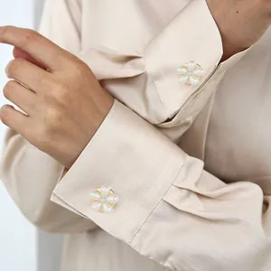 Elegant pearl and rhinestone flower cufflinks on silk shirt sleeve for women