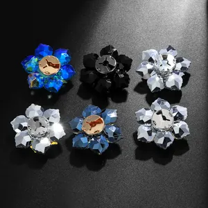 Macro shot of assorted crystal flower cufflinks with faceted petals on black background