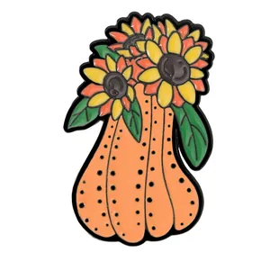Cartoon orange pumpkin enamel pin with yellow sunflower blossoms and green leaves