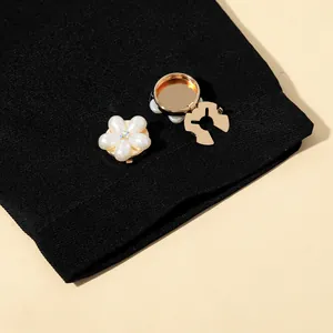 Macro shot of pearl flower brooch pin with crystal center on elegant black suit fabric