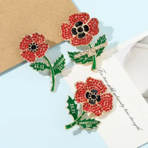 Detailed view of red poppy flower brooches with engraved Remembrance Day text on leaves