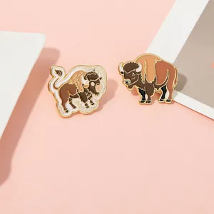 Macro detail of cartoon yak enamel pins with gold plating and decorative cloud patterns