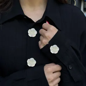 Elegant rose flower button in pearlescent finish on a black shirt for a luxury look