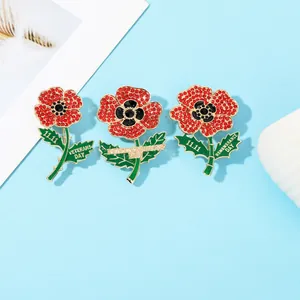 Detail of red crystal poppy brooches with Lest We Forget text for Remembrance Day