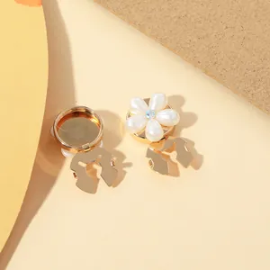 Detail of floral collar clips with white pearls, gold metal base and center crystals