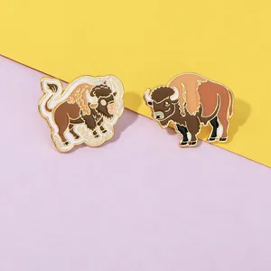 Detailed close-up of two enamel bison pins featuring brown and gold metallic finish