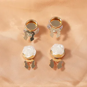 Detail of 4-piece rose and gold button clips for clothing and scarves on textured fabric