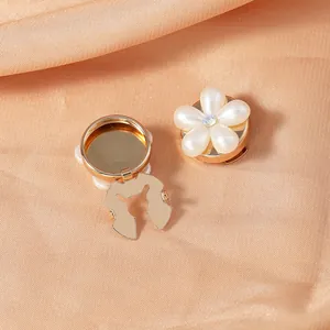 Detail of floral shirt buttons with white pearl petals and sparkling center rhinestones