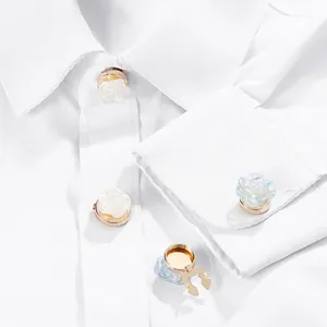 Detailed view of rose flower pins in white resin and blue crystal on a shirt