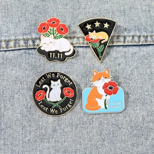 Détail des broches chat en émail et badges coquelicot sur fond de tissu denim bleu