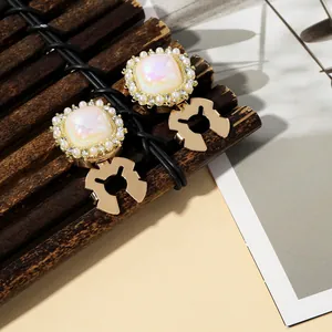 Detail of vintage gold collar clips with iridescent stones and imitation pearls