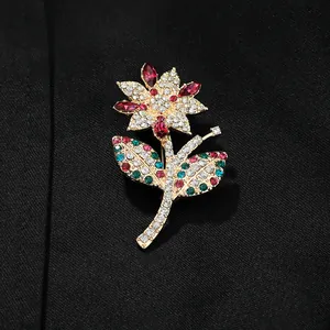 Elegante broche floral con pedrería multicolor sobre marco de metal dorado para mujer