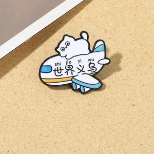 Detail of a cartoon cat enamel pin riding a white airplane badge on a textured background