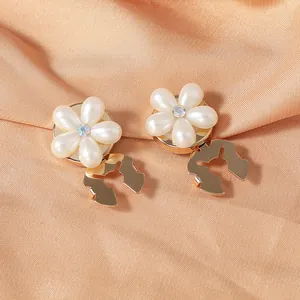 Close-up of pearl flower pins with sparkling rhinestones on golden metal for suits
