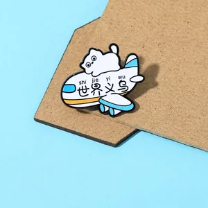 Detail of cute white cat on blue airplane enamel pin with creative Yiwu text