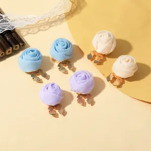 Details von Stoffrosen-Clips in Blau, Lila und Beige mit goldenen Metallclips