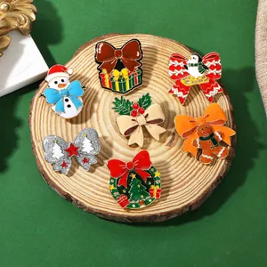 Dettaglio del set da 7 spille natalizie in lega con Babbo Natale e albero decorato