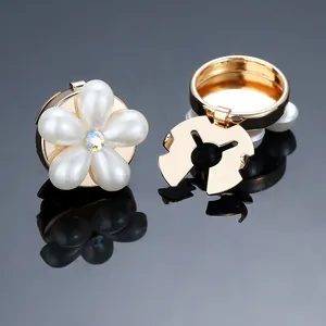 Macro shot of the elegant pearl flower button with golden metal base and sparkling crystal