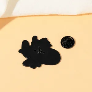 Cute black enamel cat pin badge with butterfly clutch backing on pink background