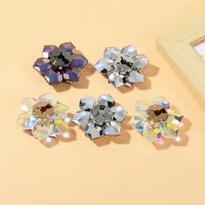 Detailed view of five crystal flower buttons in iridescent silver and purple finishes