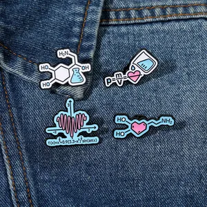 Macro detail of enamel pins with math and physics formulas on blue denim fabric
